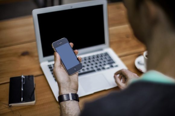 man holding a cell phone to book junk removal service