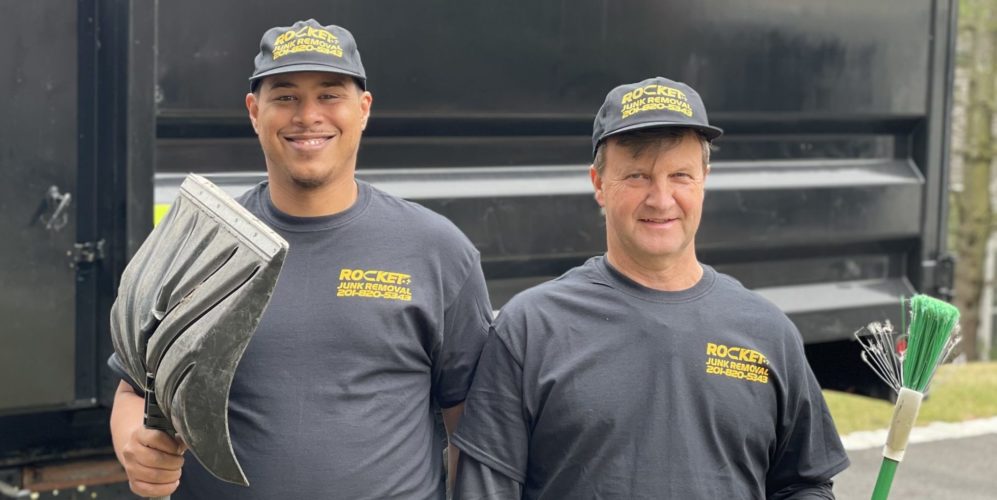 Men from Rocket Junk Removal holding shovel and broom