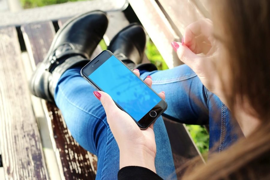 woman holding cellphone to book junk removal services