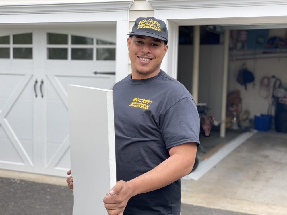 Employee from Rocket Junk Removal smiling while carrying junk stuff