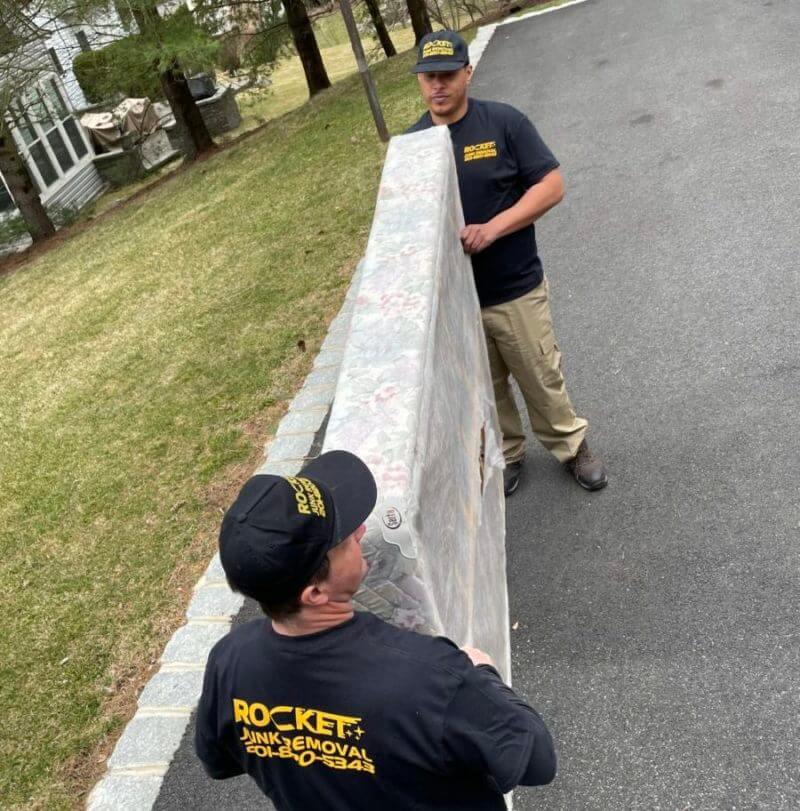 Rocket Junk Removal team hauling box spring