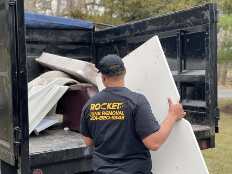 rocket junk removal expert hauling junk into the back of truck