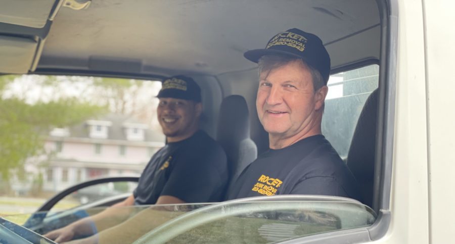 junk removal experts sitting in a junk removal truck