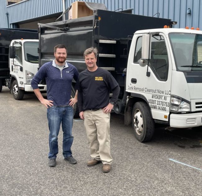 junk removal pros standing in front of junk removal truck