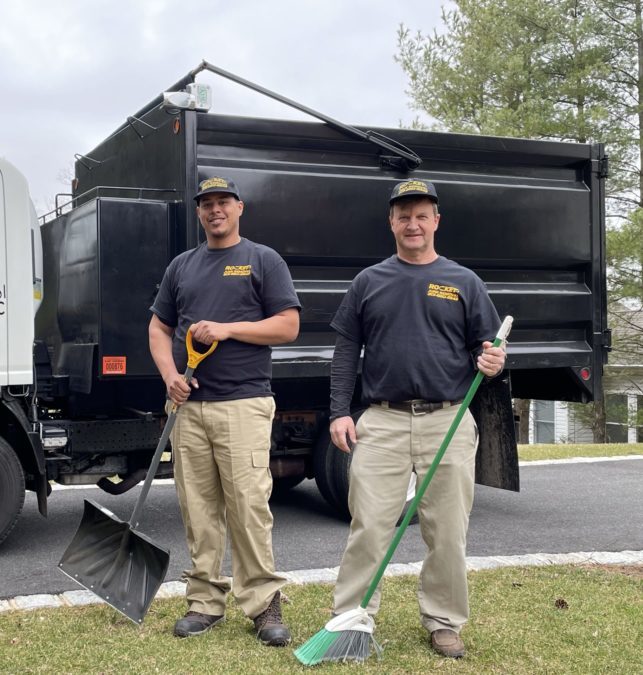 junk removal pros standing in front of rocket junk removal truck