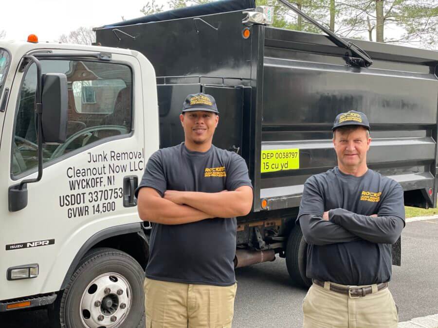 junk removal pros standing in front of junk removal truck