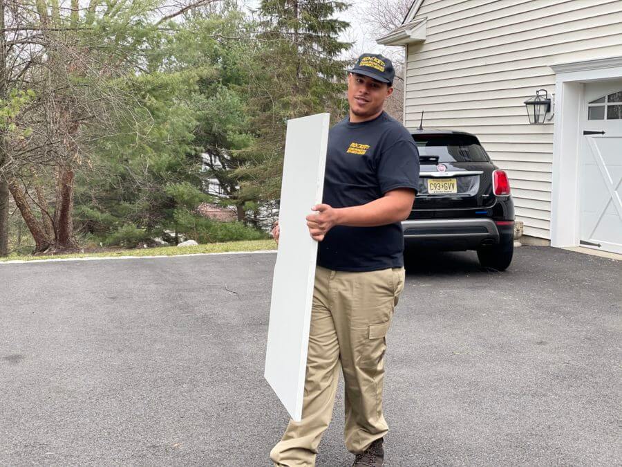 rocket junk removal pro carrying board during junk removal job