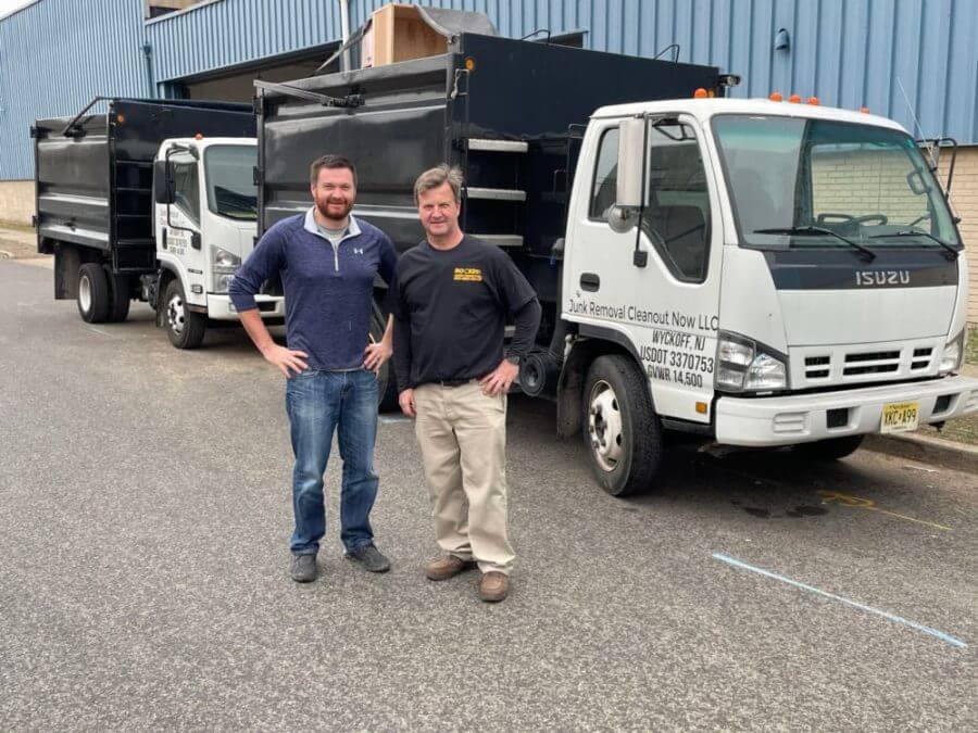 rocket junk removal pros smiling in front of junk removal truck